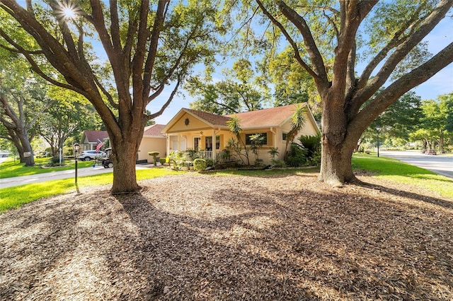 single story home featuring covered porch and a front lawn