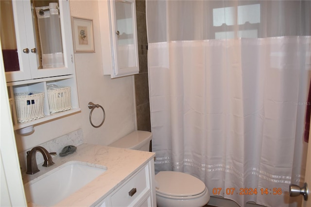 bathroom with vanity, a shower with shower curtain, and toilet