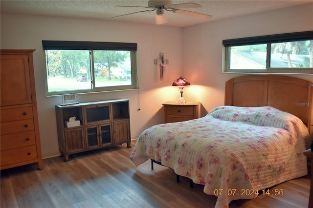 bedroom featuring ceiling fan, a textured ceiling, and hardwood / wood-style flooring