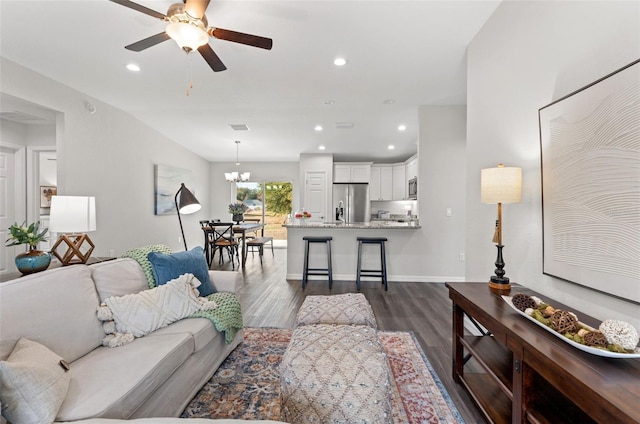 living room featuring dark hardwood / wood-style floors and ceiling fan with notable chandelier