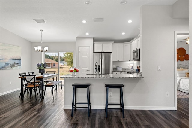 kitchen featuring light stone countertops, white cabinets, stainless steel appliances, and dark hardwood / wood-style floors