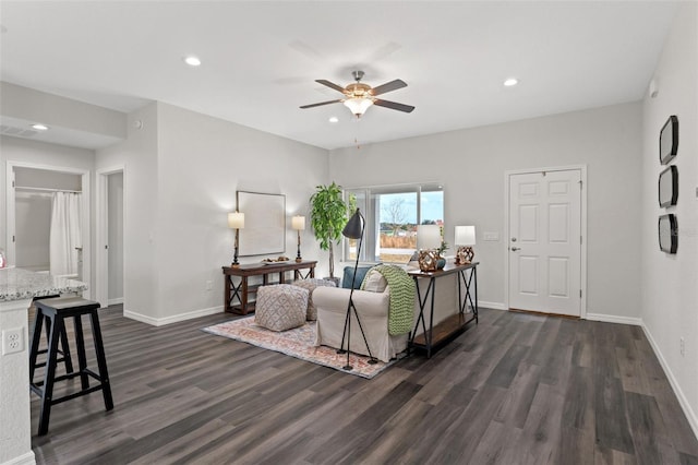 living room featuring ceiling fan and dark wood-type flooring