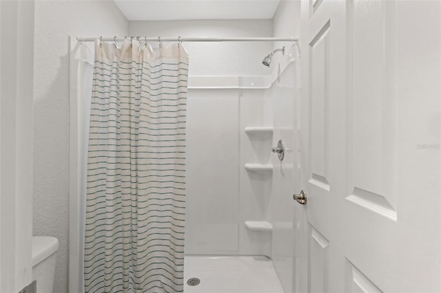 bathroom with toilet and curtained shower