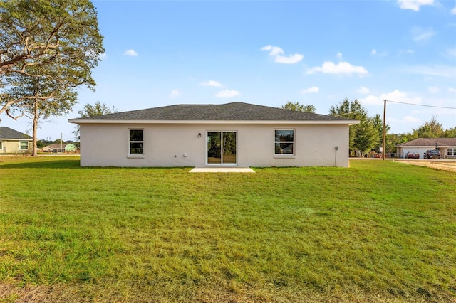 rear view of property featuring a lawn