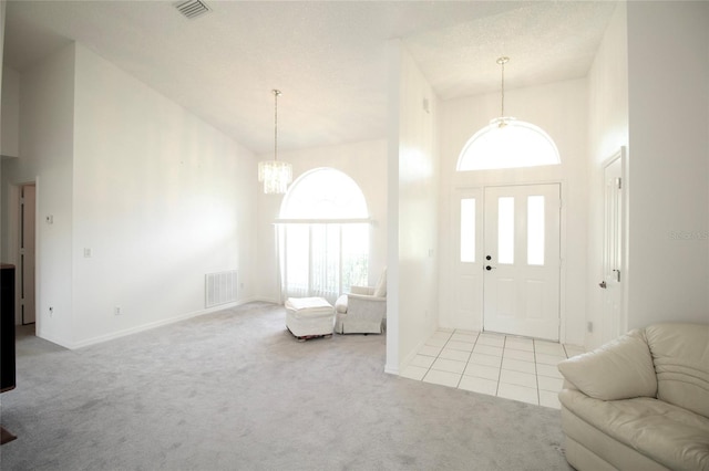 entryway featuring high vaulted ceiling, carpet floors, and an inviting chandelier