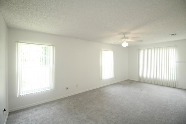 empty room featuring carpet, ceiling fan, and a textured ceiling