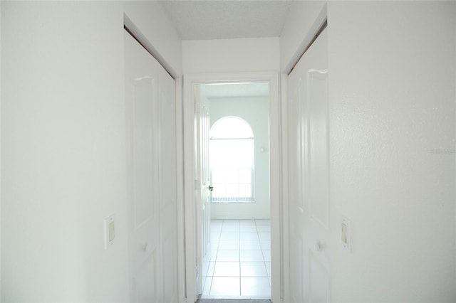 hall featuring light tile flooring