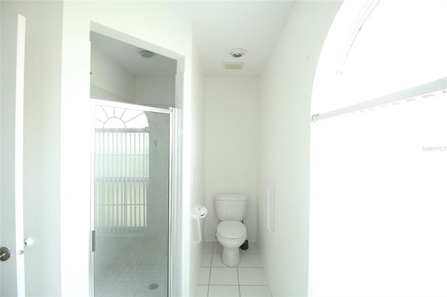 bathroom with tile floors, walk in shower, and toilet