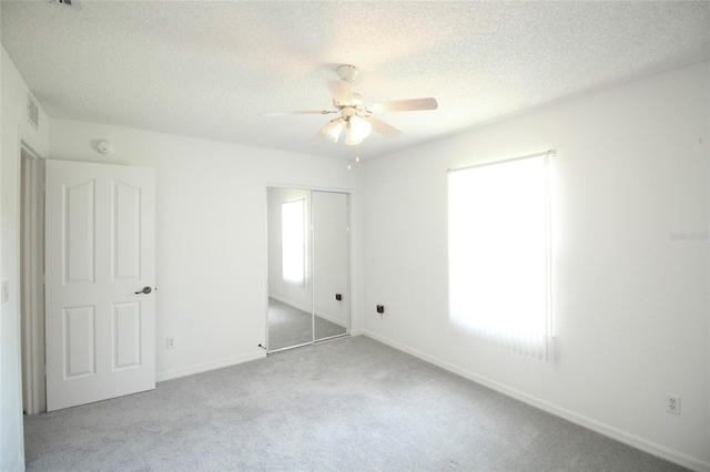 unfurnished bedroom with carpet flooring, a closet, and ceiling fan