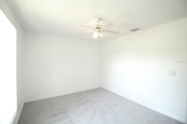 spare room with carpet, ceiling fan, and a textured ceiling