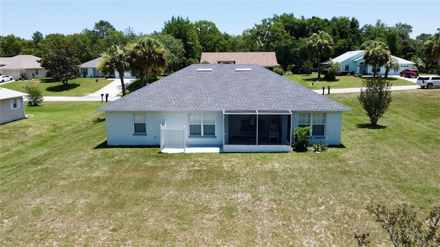 back of house featuring a sunroom and a lawn