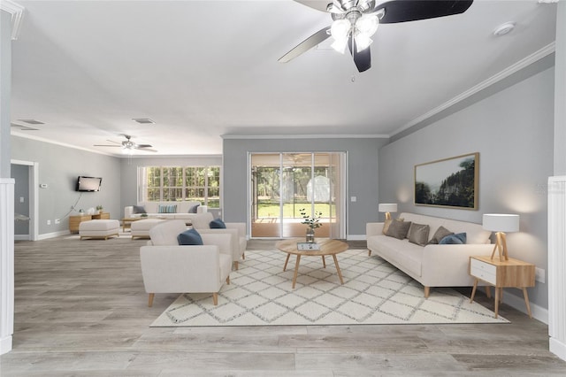 living room featuring baseboards, visible vents, ceiling fan, wood finished floors, and crown molding