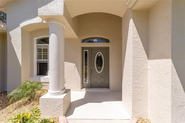 entrance to property featuring stucco siding