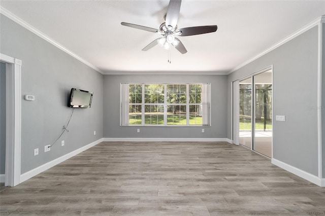 empty room featuring ornamental molding, wood finished floors, a ceiling fan, and baseboards