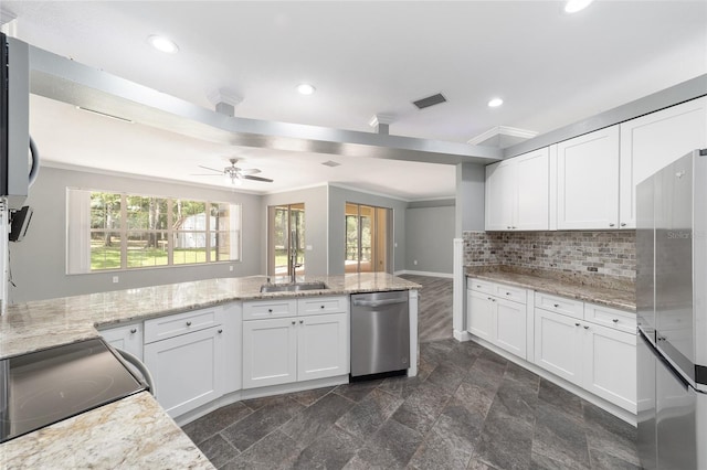 kitchen with light stone counters, stainless steel appliances, ceiling fan, sink, and white cabinetry