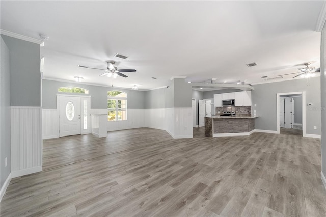 unfurnished living room with ceiling fan, crown molding, and light hardwood / wood-style flooring