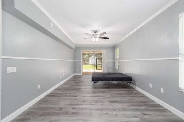 unfurnished bedroom with ornamental molding, a ceiling fan, baseboards, and wood finished floors