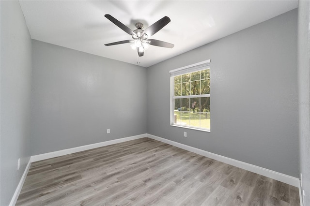 empty room with light wood finished floors, ceiling fan, and baseboards