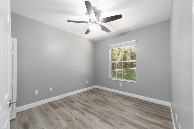 spare room with ceiling fan, baseboards, and wood finished floors