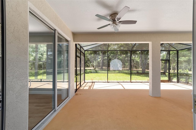 unfurnished sunroom with ceiling fan