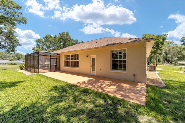 rear view of property with a patio, glass enclosure, cooling unit, a yard, and stucco siding