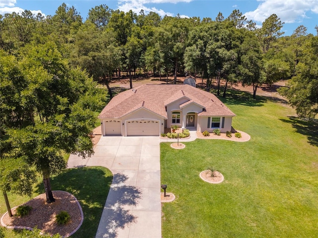 view of front of property featuring an attached garage, concrete driveway, a front yard, and stucco siding