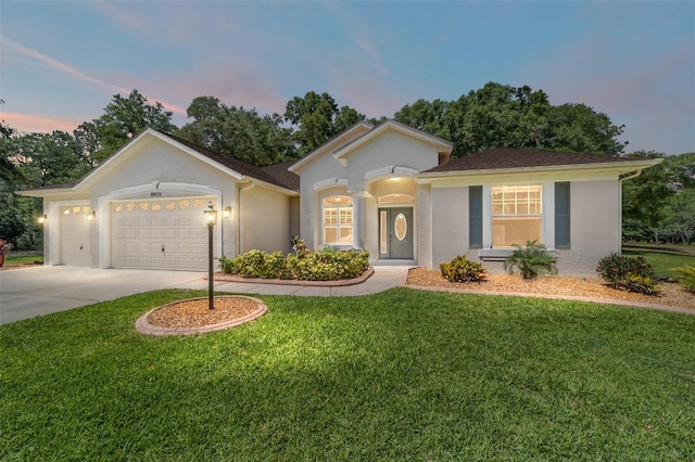 view of front of house with driveway, a front lawn, an attached garage, and stucco siding