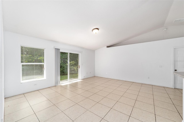 tiled spare room with lofted ceiling