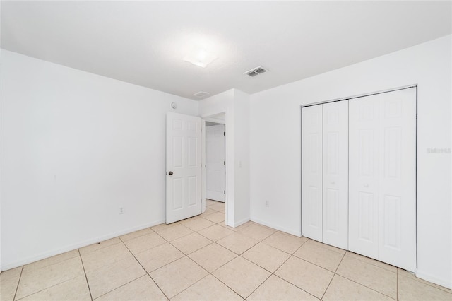 unfurnished bedroom with light tile patterned flooring and a closet