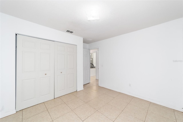 unfurnished bedroom featuring light tile patterned flooring and a closet