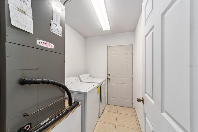 washroom featuring light tile patterned flooring, separate washer and dryer, and heating unit