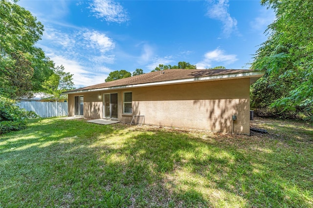 rear view of property with a lawn