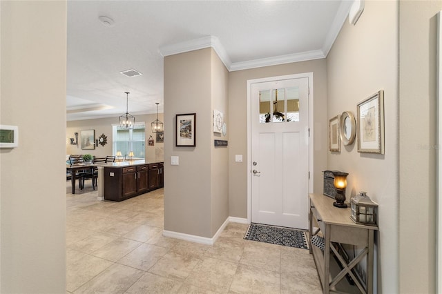 foyer entrance featuring a notable chandelier and ornamental molding