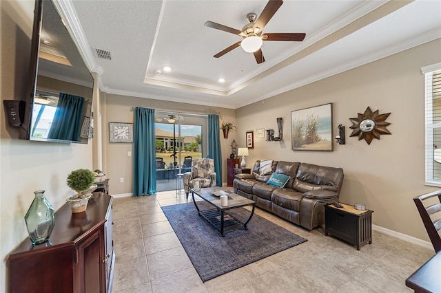 living room with a raised ceiling, crown molding, and a wealth of natural light