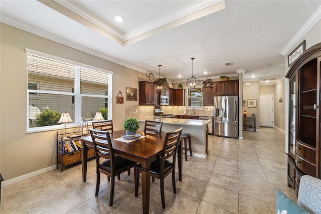 tiled dining room featuring a textured ceiling, ornamental molding, and sink