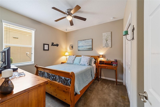 bedroom with ceiling fan and dark colored carpet