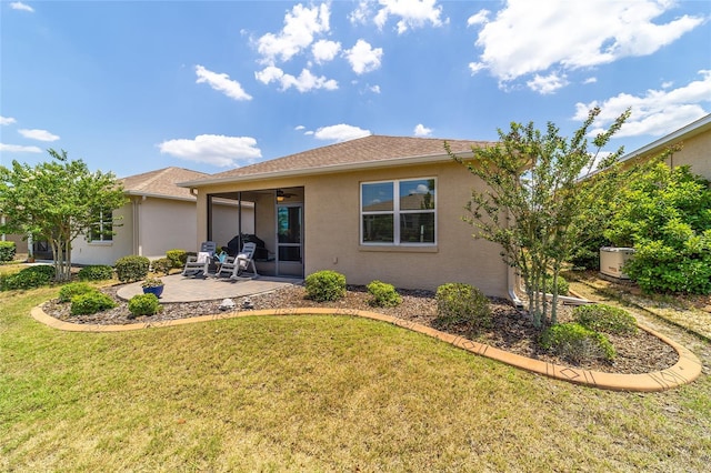 rear view of house featuring ceiling fan, a patio area, and a yard