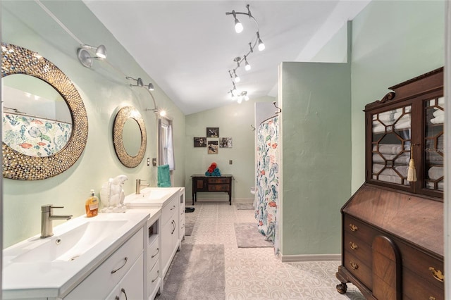 bathroom with tile patterned flooring, vaulted ceiling, and vanity