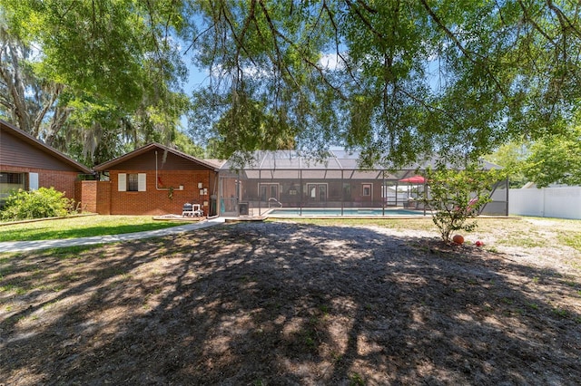 view of yard with a fenced in pool and glass enclosure