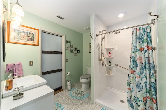 bathroom featuring toilet, vanity, tile patterned flooring, and walk in shower