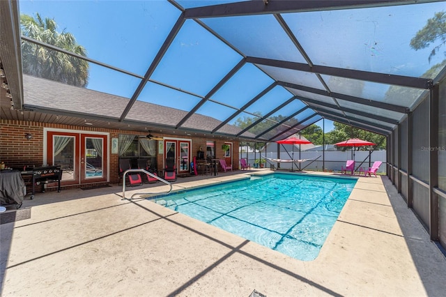 view of swimming pool featuring ceiling fan, a lanai, french doors, and a patio area