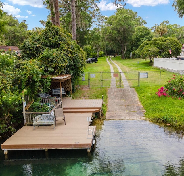 view of dock featuring a yard and a deck with water view