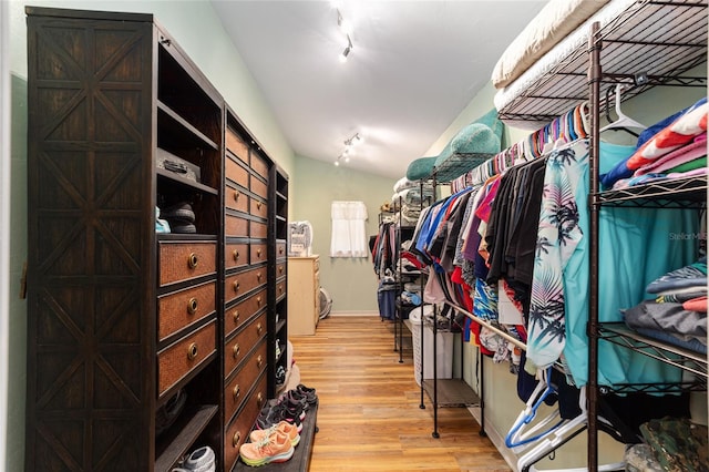 walk in closet with lofted ceiling and light wood-type flooring