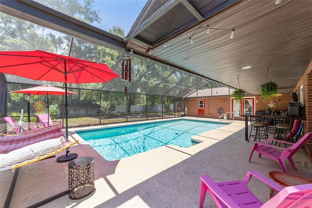 view of swimming pool with a lanai, a bar, and a patio