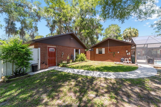 back of property featuring a lanai and a yard