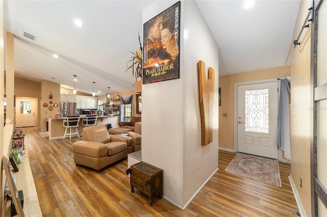 foyer entrance with lofted ceiling and hardwood / wood-style floors