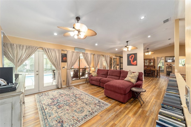 living room featuring lofted ceiling, french doors, ceiling fan, and light hardwood / wood-style floors