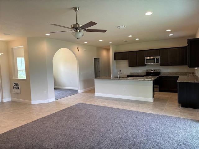 kitchen featuring light tile patterned flooring, appliances with stainless steel finishes, ceiling fan, sink, and an island with sink