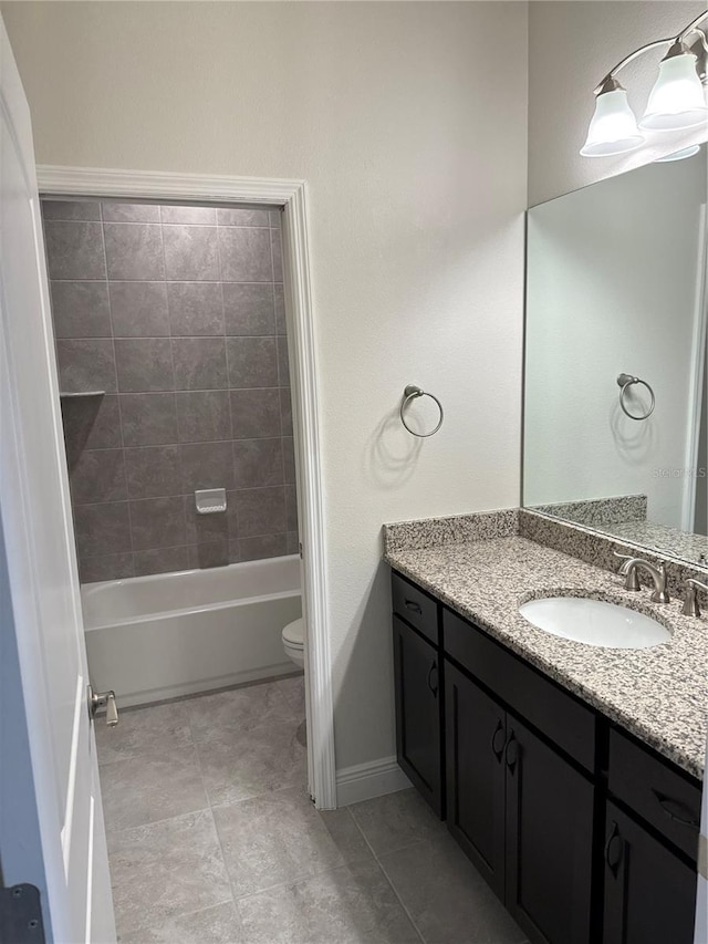 full bathroom featuring tiled shower / bath, vanity, and toilet