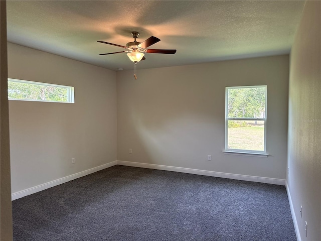 carpeted empty room featuring ceiling fan, a healthy amount of sunlight, and a textured ceiling